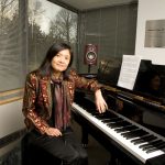Noriko Manabe sitting at a piano